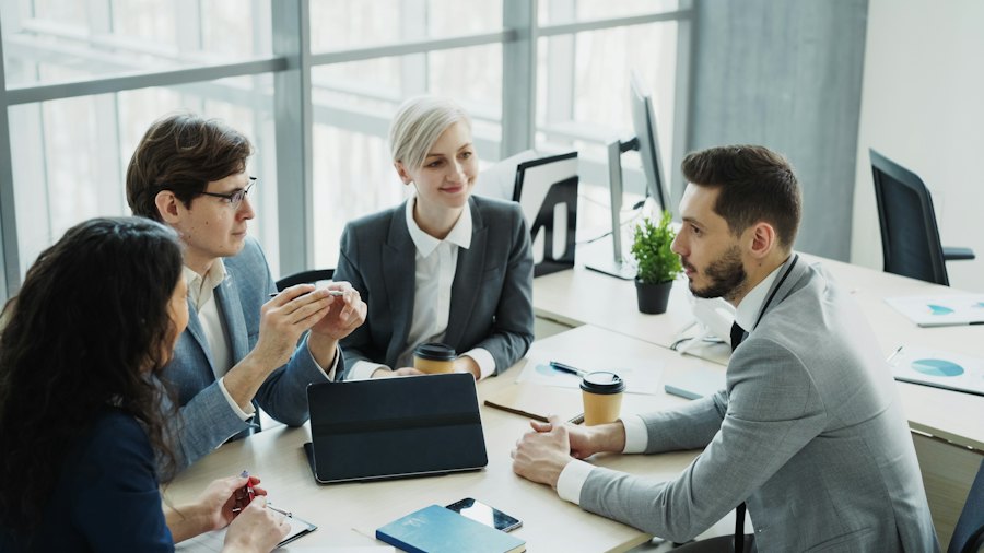 A business team in conversation around a table in a bright office